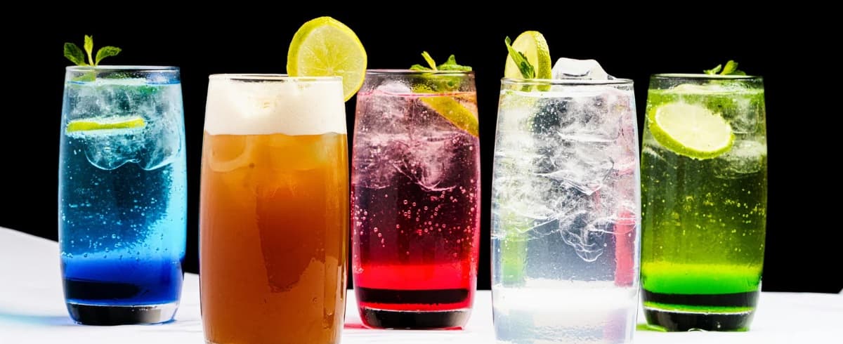 Glasses of juice and soft drinks alongside food-grade activated carbon \u2014 carbon purifies beverage syrups, concentrates and process water