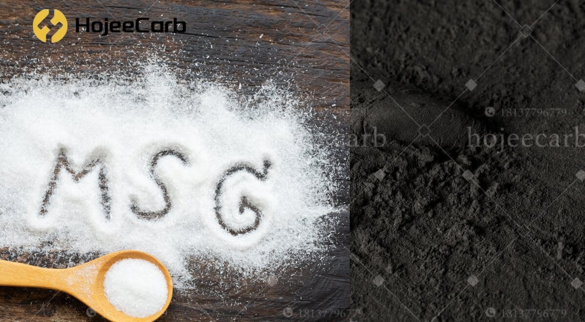 White MSG crystals spelling MSG on a wooden surface with a spoon of the powder on the left, and a mound of fine black powdered activated carbon on the right — decolorizing agent for MSG production