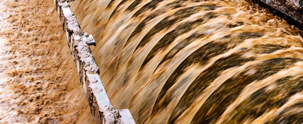Turbulent wastewater cascading over a weir — activated carbon for industrial wastewater treatment