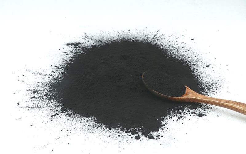 Wood-based powdered activated carbon close-up showing fine black powder texture