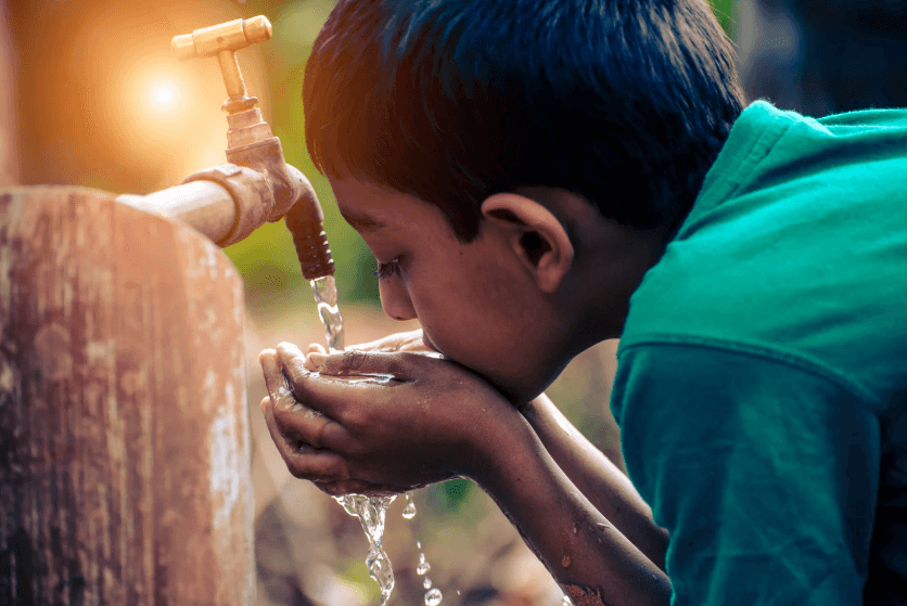 Child drinking clean filtered water — catalytic carbon removes chloramines for safe drinking water