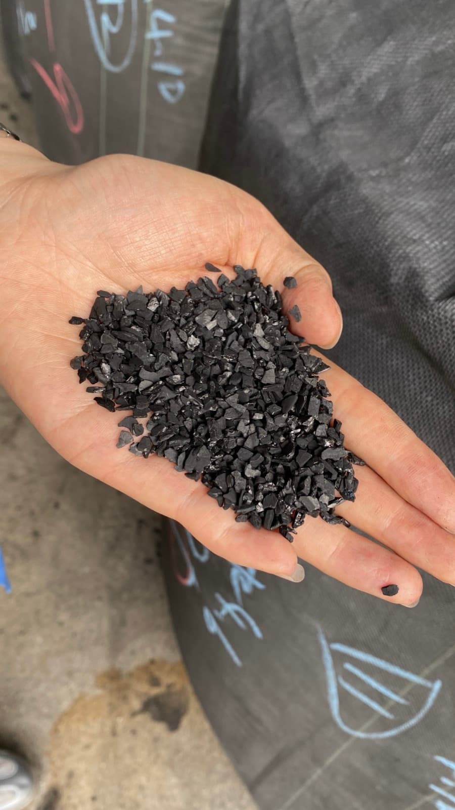 Coconut shell gold-recovery activated carbon granules held in hand